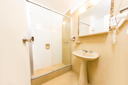 y baño con ducha y lavamanos. en Costanera Hotel en Villa Carlos Paz
