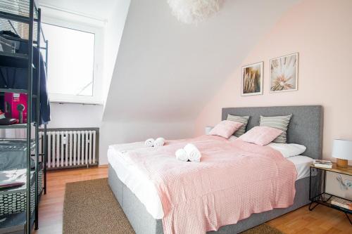 - une chambre avec un lit rose et 2 serviettes dans l'établissement Modern~5*Location~Home Office~Netflix~Free Parking, à Essen