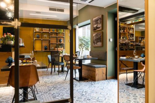 uma sala de jantar com mesas e cadeiras e uma janela em Avenue Boutique Hotel em Como