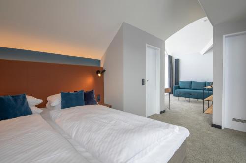 a bedroom with a large bed and a blue couch at Domizil Tübingen in Tübingen