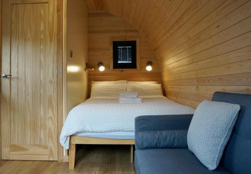 a bedroom with a bed in a wooden room at Habberley Glamping Pods in Shrewsbury