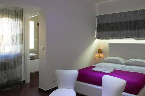 レッジョ・ディ・カラブリアにあるB&B La Terrazza Sul Duomoの白いベッドルーム(紫色のベッド1台、白い椅子2脚付)