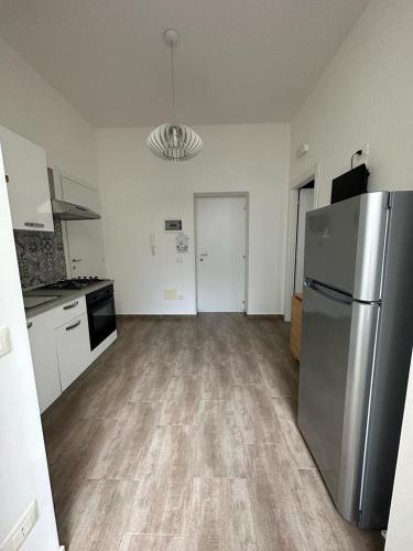 a kitchen with a stainless steel refrigerator in an empty room at RAUDINO ROOMS in Siracusa