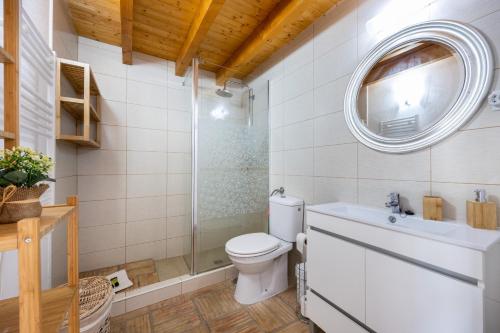 a bathroom with a toilet and a sink and a mirror at Casa Joia by Seewest in Bensafrim