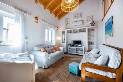 a living room with a couch and a tv at Casa Joia by Seewest in Bensafrim