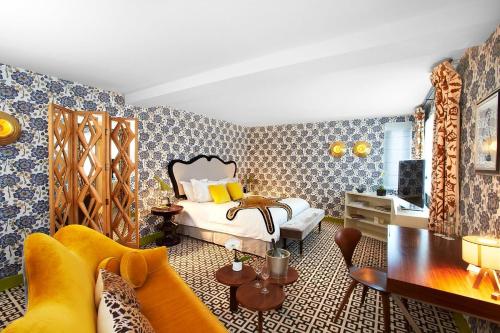 - une chambre avec un lit, un canapé et une table dans l'établissement Hôtel Thoumieux, à Paris