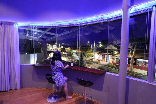 a girl standing at a bar looking out of a window at Margaret River Mainstreet Apartment in Margaret River Town