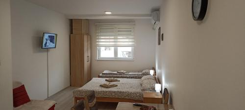 um pequeno quarto com 2 camas e uma janela em Studio Bane em Sokobanja