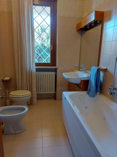 a bathroom with a tub and a toilet and a sink at Appartamento intero in casa indipendente in Biella