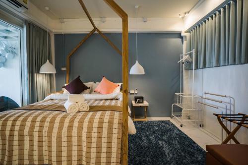 ein Schlafzimmer mit einem Bett mit einer karierten Decke in der Unterkunft Loft Comfy Stay Near Uni For Friends Family in Chiang Mai
