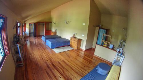 a living room with a blue couch and a wooden floor at Villa Boa Vista in Madalena