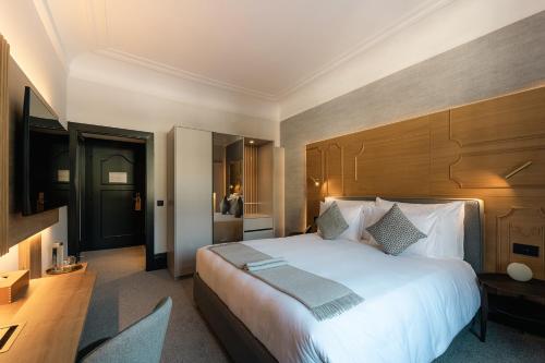 a bedroom with a large bed with a wooden headboard at Villars Palace in Villars-sur-Ollon