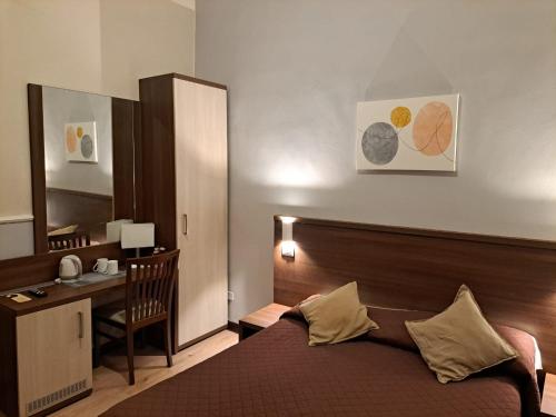 1 dormitorio con cama, escritorio y espejo en Hotel Leone en Roma