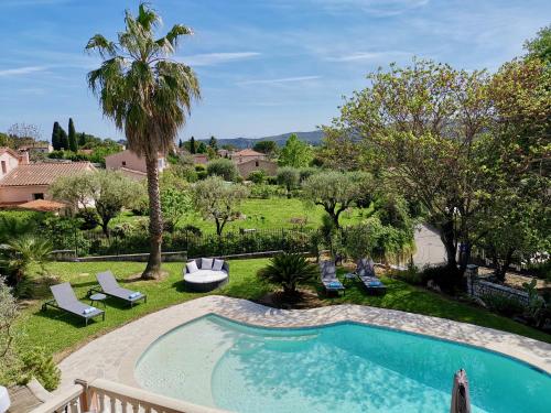 - une piscine dans une cour avec des chaises et des arbres dans l'établissement Maison Saint Paul BnB, à La Colle-sur-Loup