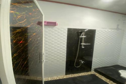 uma casa de banho com uma cabina de duche em vidro e um WC. em EXPRESS O 92147 Nia Residence em Depok