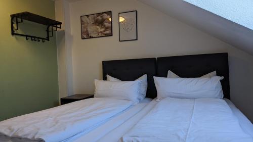 two beds in a room with white sheets and pillows at Europa City Apartment in Saarbrücken