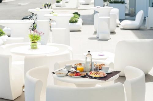 a plate of food on a table with white chairs at 8Piuhotel in Lecce