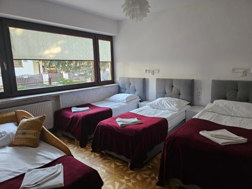 Habitación con 4 camas y ventana en WILLA BAJLAND en Varsovia
