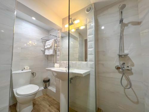 La salle de bains est pourvue d'une douche, de toilettes et d'un lavabo. dans l'établissement Hotel Rila, à Doupnitsa