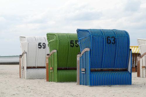 - un groupe de chaises longues sur la plage dans l'établissement Ferienhaus Wattwurm 1, FeWo Vermittlung Nordsee, à Dangast