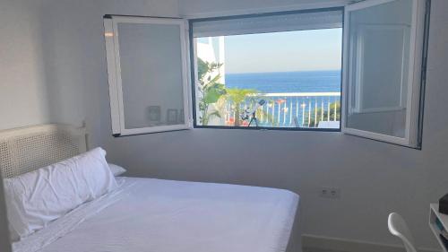 1 dormitorio con cama y ventana con vistas al océano en Apartamento Embarcadero de Calahonda, en Calahonda