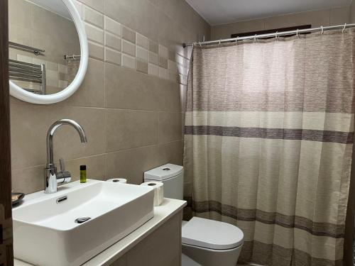 La salle de bains est pourvue d'un lavabo, de toilettes et d'un miroir. dans l'établissement Chioni Cottage by AgroHolidays, à Kyperoúnta