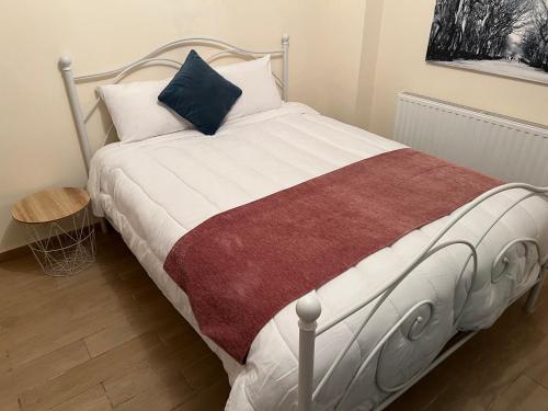 - une chambre avec un lit doté de draps blancs et d'un oreiller bleu dans l'établissement Chioni Cottage by AgroHolidays, à Kyperoúnta