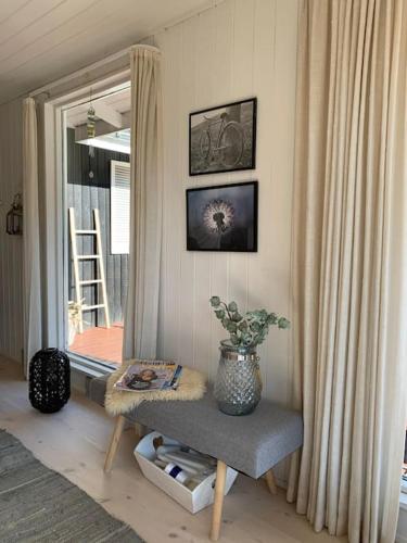 a room with a chair with a vase on it at En perle af et sommerhus tæt på både strand og by in Hornbæk