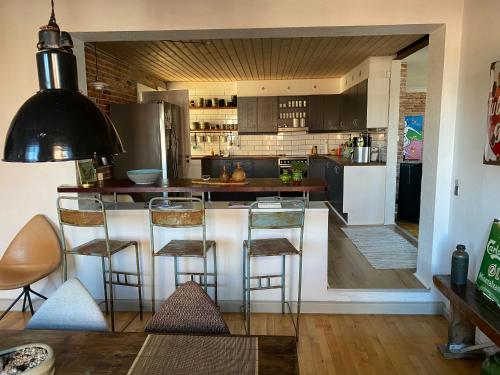 a kitchen with a bar with stools in it at feriehus med havudsigt in Spodsbjerg