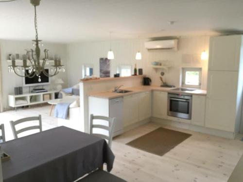a kitchen with a table and a table and a dining room at En perle af et sommerhus tæt på både strand og by in Hornbæk