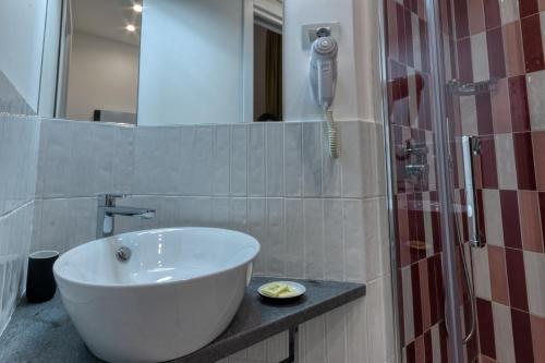 a bathroom with a white sink and a phone at La Dimora di Nonna Maria in Maiori