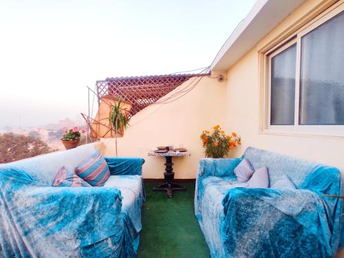 un patio con 2 sofás azules y una mesa en Roof for rent, Street 9, Maadi, en El Cairo