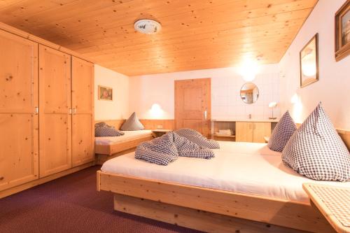 2 Betten in einem Zimmer mit Holzdecken in der Unterkunft Ferienhof Haderlehn in Sautens