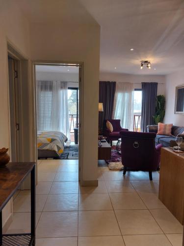 a living room with a couch and a bed at Forest View Apartments in Kololi