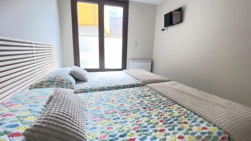 two beds sitting next to each other in a bedroom at Lapaserina B in Arenas de Cabrales