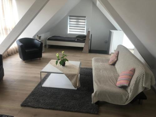 ein Wohnzimmer mit einem Sofa und einem Tisch in der Unterkunft Willa chez willi in Niederschaeffolsheim