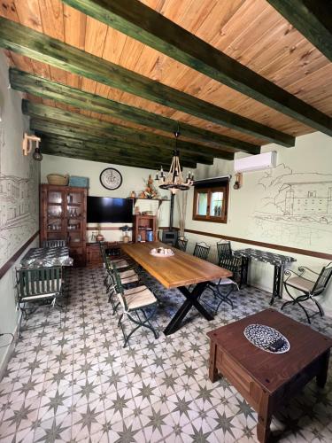 sala de estar con mesa de madera y sillas en Casa Rural Juan de Austria, en Cuacos de Yuste