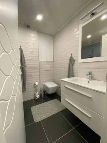 ein weißes Badezimmer mit Waschbecken und Toilette in der Unterkunft New World in Bihać