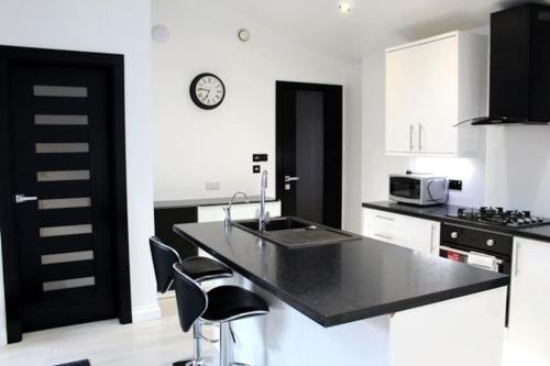 a kitchen with a sink and a black counter top at Annex at Orchard House - Strictly No Parties in Barton in the Clay