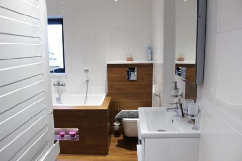 a bathroom with a tub and a sink and a toilet at Annex at Orchard House - Strictly No Parties in Barton in the Clay