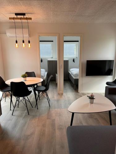 a living room with two tables and a couch and a television at Esbjerg Camping in Esbjerg