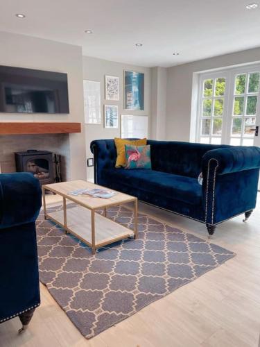 a living room with a blue couch and a coffee table at A luxury unique home spa - White Stones Retreats. in Weymouth