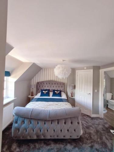 a large bedroom with a large bed with blue pillows at A luxury unique home spa - White Stones Retreats. in Weymouth