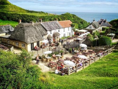 ein Dorf mit Tischen und Sonnenschirmen und dem Meer in der Unterkunft A luxury unique home spa - White Stones Retreats. in Weymouth