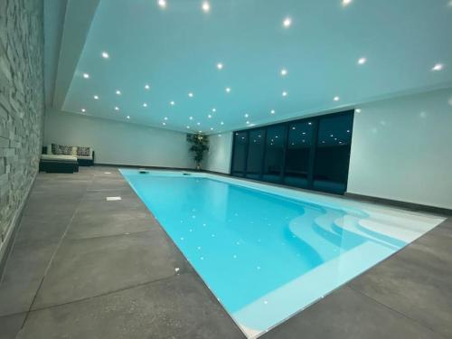 ein Pool in einem Gebäude mit blauer Beleuchtung in der Unterkunft A luxury unique home spa - White Stones Retreats. in Weymouth