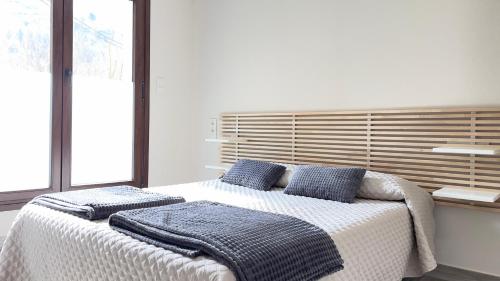 Un dormitorio con una cama con almohadas azules. en Lapaserina-A, en Arenas de Cabrales