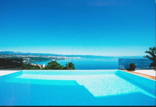a large swimming pool with a view of the water at Villa Sunrise With Sea View in Rogač