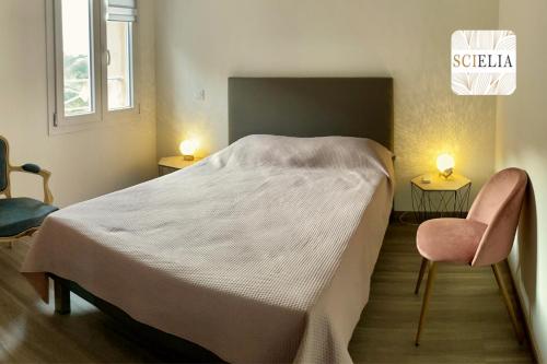 um quarto com uma cama grande e uma cadeira rosa em Chez Françoise em Porto Ota