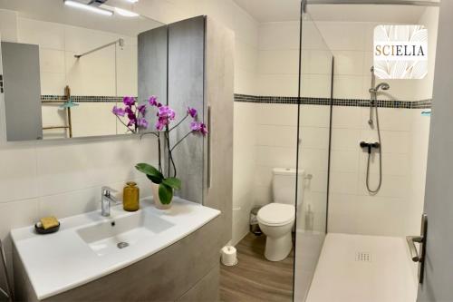 een badkamer met een wastafel, een toilet en een douche bij Chez Françoise in Porto Ota