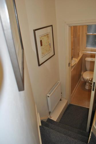 a staircase leading to a bathroom with a toilet at Town House Rooms in Hastings